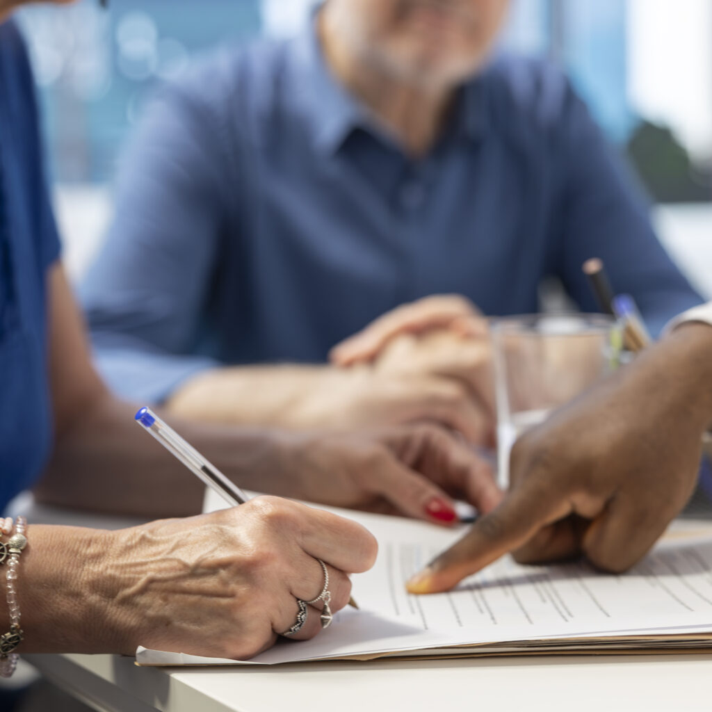 Middle aged woman signing retirement plan contract to secure the future income, investing money to cover family expenses. Senior people agreeing to life insurance policy in office.